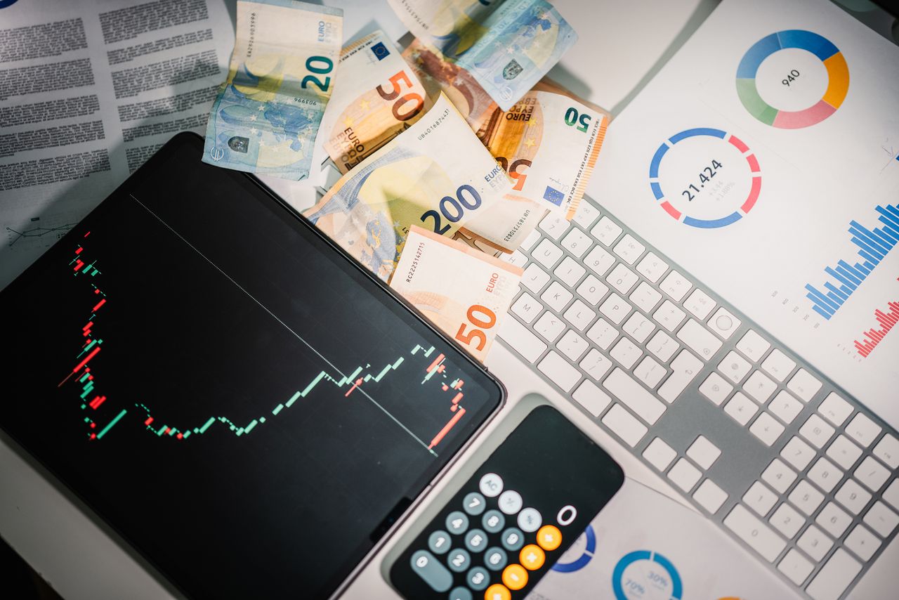 services-02 Vue de dessus d’outils financiers avec des billets en euros posés sur un bureau, illustrant les tendances du marché et des graphiques.